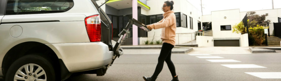 woman putting the wheelchair inside the wheelchair accessible car hire